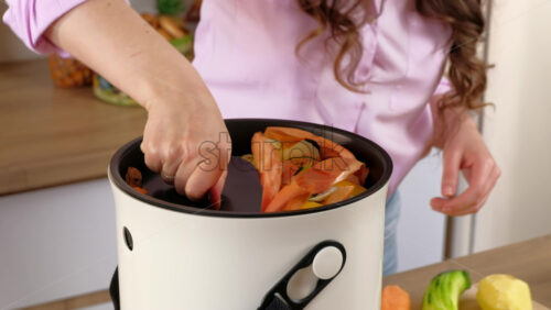 Video - Woman recycling organic waste by composting vegetables peels in the Bokashi in the kitchen