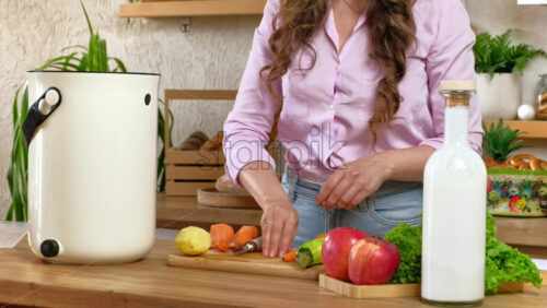 Video - Woman peeling vegetables and recycling organic waste by composting in the Bokashi in the kitchen