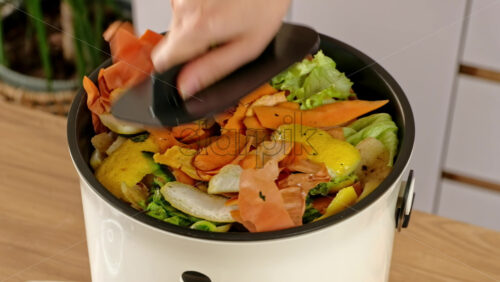Video - Woman recycling organic waste by composting vegetables peels in the Bokashi in the kitchen