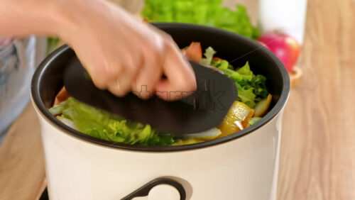 Video - Woman recycling organic waste by composting vegetables peels in the Bokashi in the kitchen