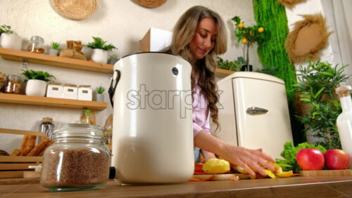Video - Woman recycling organic waste by composting vegetables peels in the Bokashi in the kitchen