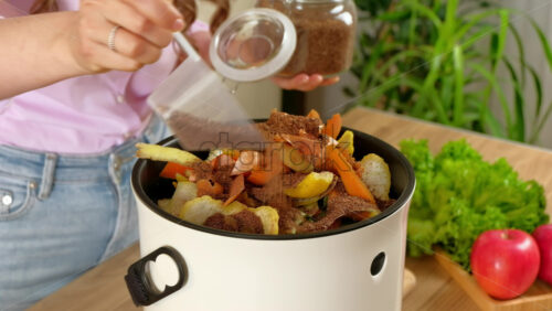 Video - Woman recycling organic waste by pouring Bokashi bran on the vegetable peels. in the kitchen