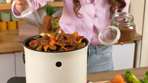 Video - Woman recycling organic waste by pouring Bokashi bran on the vegetable peels. in the kitchen