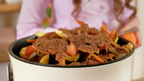 Video - Woman recycling organic waste by composting vegetables peels in the Bokashi in the kitchen