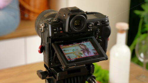 Video - Camera filming a woman drinking a glass of red wine and dancing in the kitchen