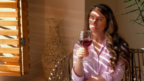 Video - Woman savouring a glass of red wine in daylight