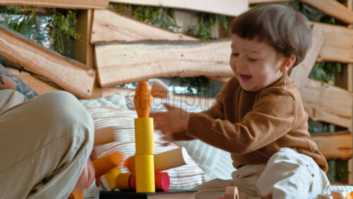 Video - Man playing with child with colourful wooden toys on the bed