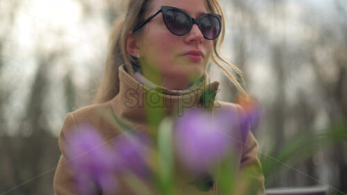 Video - Brunette woman in brown coat drinking tea at a terrace