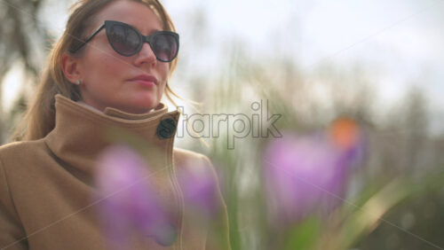 Video - Brunette woman in brown coat sitting at a terrace