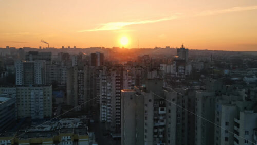 Video - Aerial drone view of Chisinau at sunset. Multiple residential buildings. Bare trees, winter