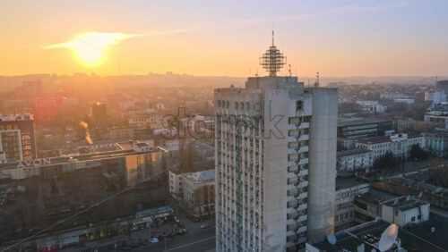 Video - CHISINAU, MOLDOVA - JANUARY 17, 2021: Aerial drone view of an high office building, road with multiple cars. Bare trees, winter
