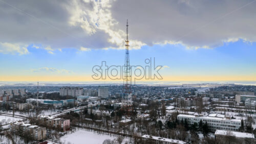 Video - Aerial drone hyperlapse timelapse of the radio transmission tower in the daylight. Ground covered in snow in Chisinau, Moldova