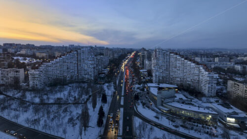 Video - Aerial drone hyperlapse timelapse of the City Gates with multiple buildings and moving traffic at sunset. Winter in Chisinau, Moldova