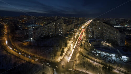 Video - Aerial drone hyperlapse timelapse of the City Gates with multiple buildings and moving traffic in the evening, blue hour. Winter in Chisinau, Moldova