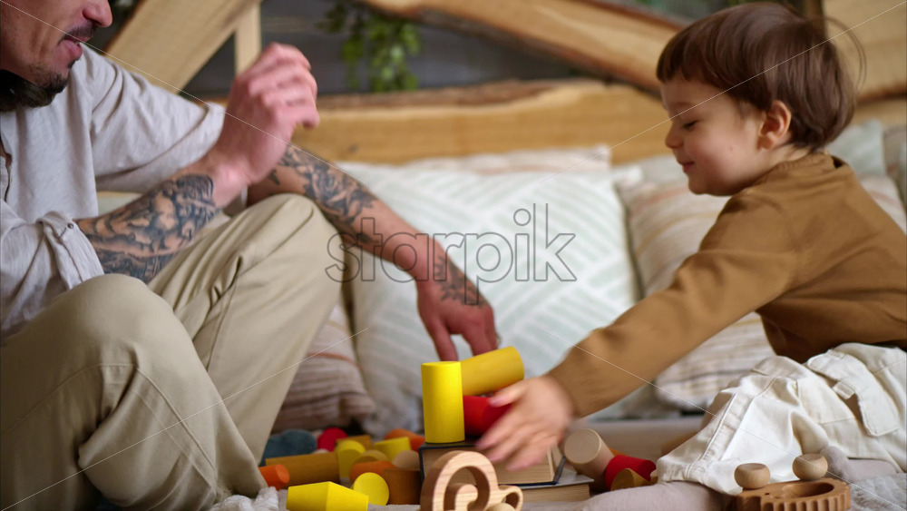 Video - Father playing with his son with colourful, ecological wooden toys on the bed