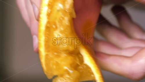 Video - A woman squeezes juice from an orange. Slow motion