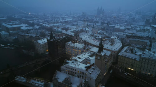Video - Aerial drone view of the Old Town square covered in snow in the evening. Winter in Prague, Czech Republic