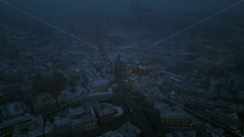 Video - Aerial drone view of the Old Town square covered in snow in the night. Winter in Prague, Czech Republic