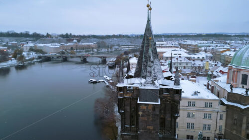 Video - Aerial drone view of the Powder Tower near the Charles bridge in Prague. City covered in snow. Winter in Czech Republic