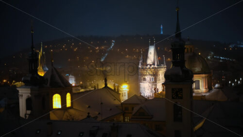 Video - Powder Tower surrounded by medieval building, covered in snow in the night. Winter in Prague, Czech Republic