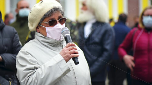 Video - CHISINAU, MOLDOVA - APRIL 28, 2021: Woman talking in the microphone. People protesting for snap elections in front of constitutional court building. Slow motion