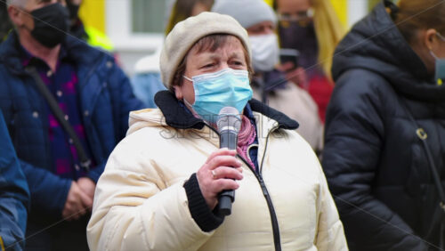 Video - CHISINAU, MOLDOVA - APRIL 28, 2021: Woman talking in the microphone. People protesting for snap elections in front of constitutional court building. Slow motion
