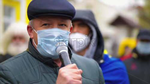 Video - CHISINAU, MOLDOVA - APRIL 28, 2021: Man talking in the microphone. People protesting for snap elections in front of constitutional court building. Slow motion
