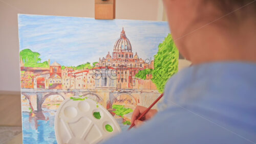 Video - Woman painting picture on the easel holding a palette. Home, slow motion