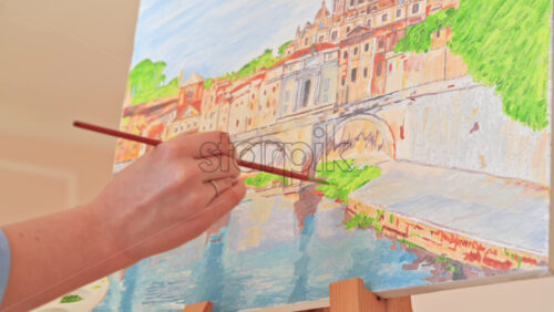 Video - Woman painting picture on the easel holding a palette at home