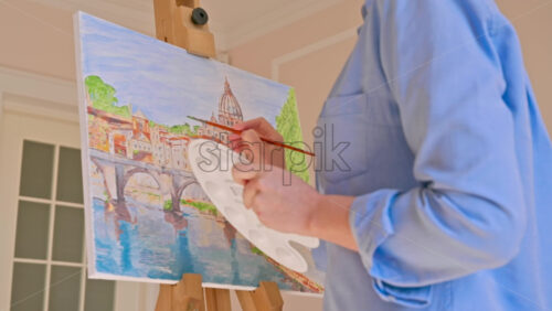 Video - Caucasian woman painting a picture with a palette in her hands, indoors. Slow motion