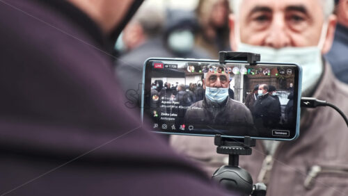 Video - CHISINAU, MOLDOVA - APRIL 28, 2021: Shooting of a talking man on smartphone. People protesting for snap elections in front of constitutional court building