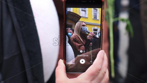 Video - CHISINAU, MOLDOVA - APRIL 28, 2021: Woman shooting a talking woman on smartphone. People protesting for snap elections in front of constitutional court building