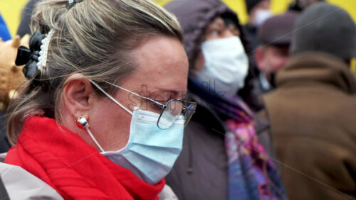 Video - CHISINAU, MOLDOVA - APRIL 28, 2021: Woman in medical mask and glasses. People protesting for snap elections in front of constitutional court building