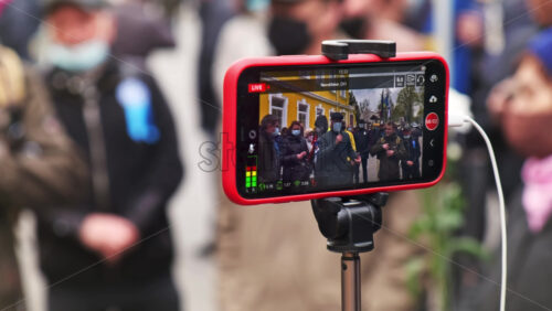 Video - CHISINAU, MOLDOVA - APRIL 28, 2021: Shooting of a group of talking people on smartphone. People protesting for snap elections in front of constitutional court building