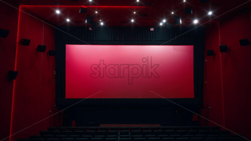 Video - Large empty movie theater auditorium with illumination and blank screen