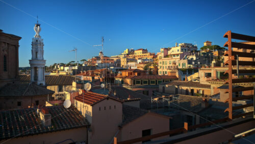 Video - Rome city skyline from a rooftop with typical terracotta tile roofs of the buildings. Sunset in Italy