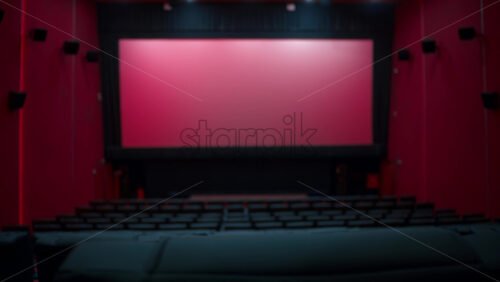 Video - Woman taking her seat in a large empty movie theater auditorium with illumination and blank screen