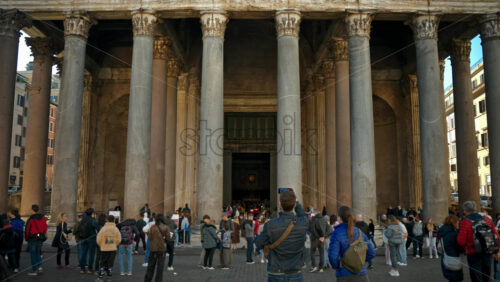 Video - Rome, Italy - February 14, 2024: Tourists walking near the Pantheon located in the city center under blue sky. Famous ancient building with white columns in touristic city