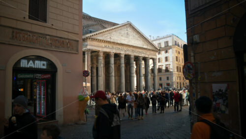 Video - Rome, Italy - February 14, 2024: Tourists walking near the Pantheon located in the city center under blue sky. Famous ancient building with white columns in touristic city