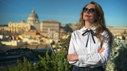 Video - Young, brunette woman, with blurred panoramic view of Vatican City, Rome, in the background