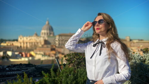 Video - Young, brunette woman, with blurred panoramic view of Vatican City, Rome, in the background