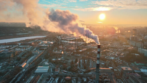 Video - Aerial drone view of Chisinau at sunrise. Thermal station with smoke coming out of the tube. Buildings, roads and bare trees. Good weather, snow on the ground. Moldova