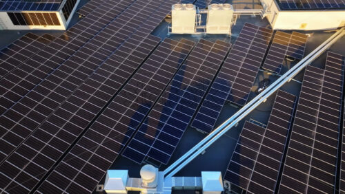 Video - Aerial drone view of solar panels at sunset. Photovoltaics on top of the roof of the building. Alternative electricity source. Concept of sustainable resources