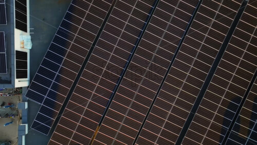 Video - Aerial drone view of solar panels at sunset. Photovoltaics on top of the roof of the building. Alternative electricity source. Concept of sustainable resources