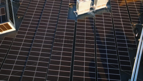 Video - Aerial drone view of solar panels at sunset. Photovoltaics on top of the roof of the building. Alternative electricity source. Concept of sustainable resources