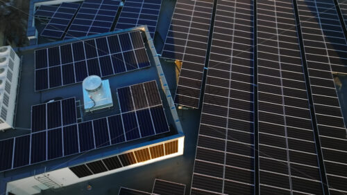 Video - Aerial drone view of solar panels at sunset. Photovoltaics on top of the roof of the building. Alternative electricity source. Concept of sustainable resources