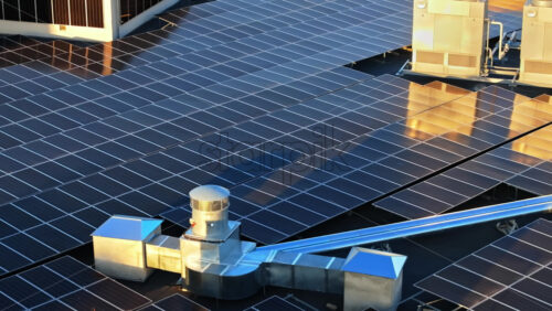 Video - Aerial drone view of solar panels at sunset. Photovoltaics on top of the roof of the building. Alternative electricity source. Concept of sustainable resources
