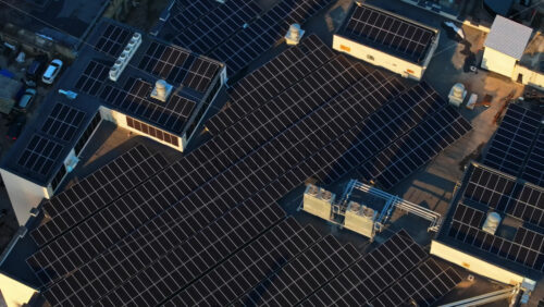 Video - Aerial drone view of solar panels at sunset. Photovoltaics on top of the roof of the building. Alternative electricity source. Concept of sustainable resources