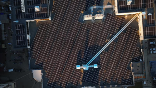 Video - Aerial drone view of solar panels at sunset. Photovoltaics on top of the roof of the building. Alternative electricity source. Concept of sustainable resources