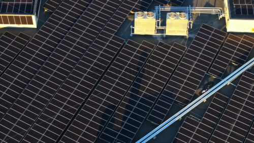 Video - Aerial drone view of solar panels at sunset. Photovoltaics on top of the roof of the building. Alternative electricity source. Concept of sustainable resources